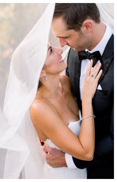 Bride beneath her veil with her groom
